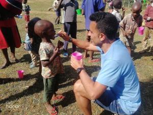 Volunteer teaching a child how to brush teeth. Photo